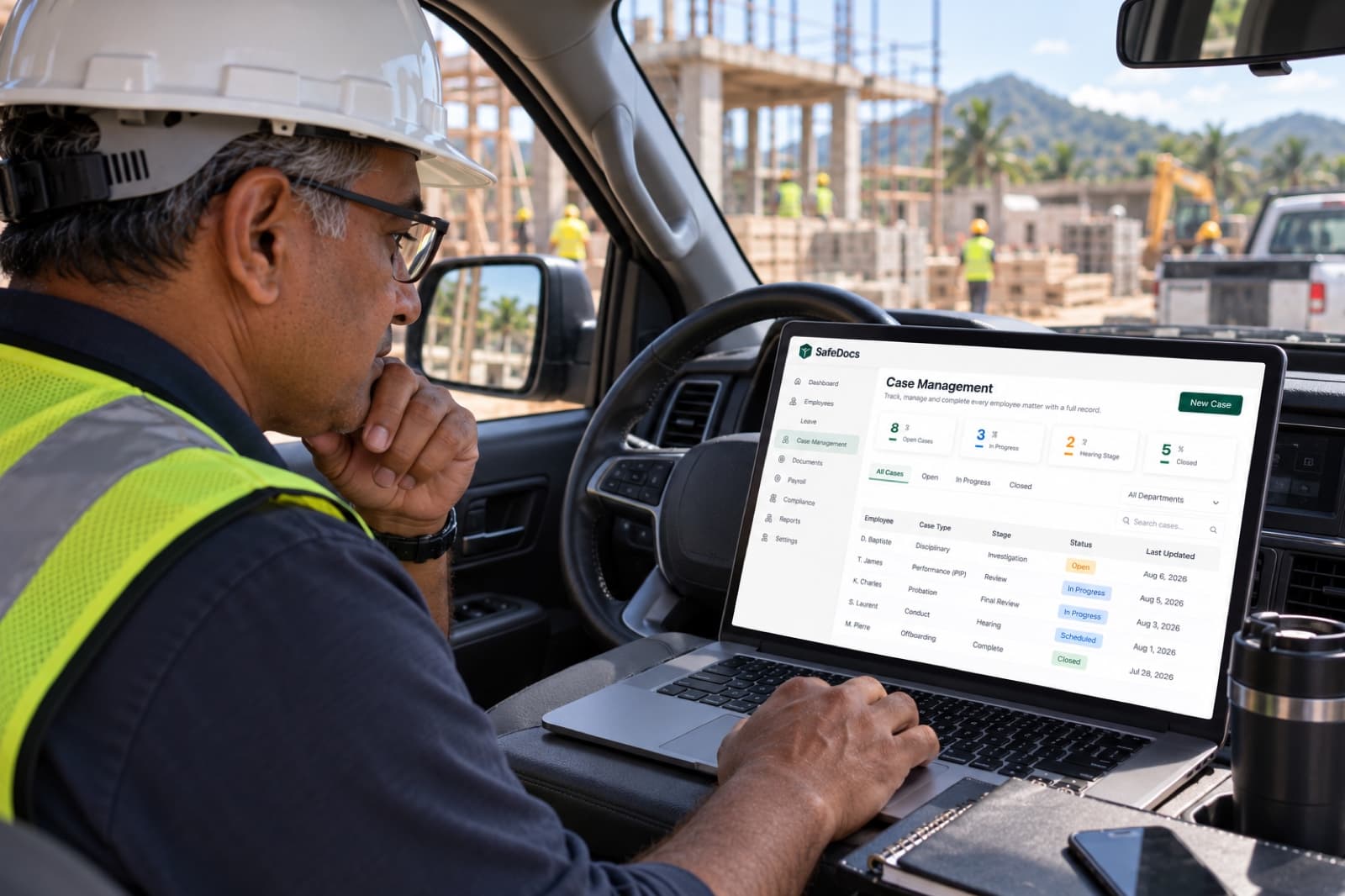 The SafeDocs Case Management screen showing open, in-progress and closed cases, open on a laptop on a construction site