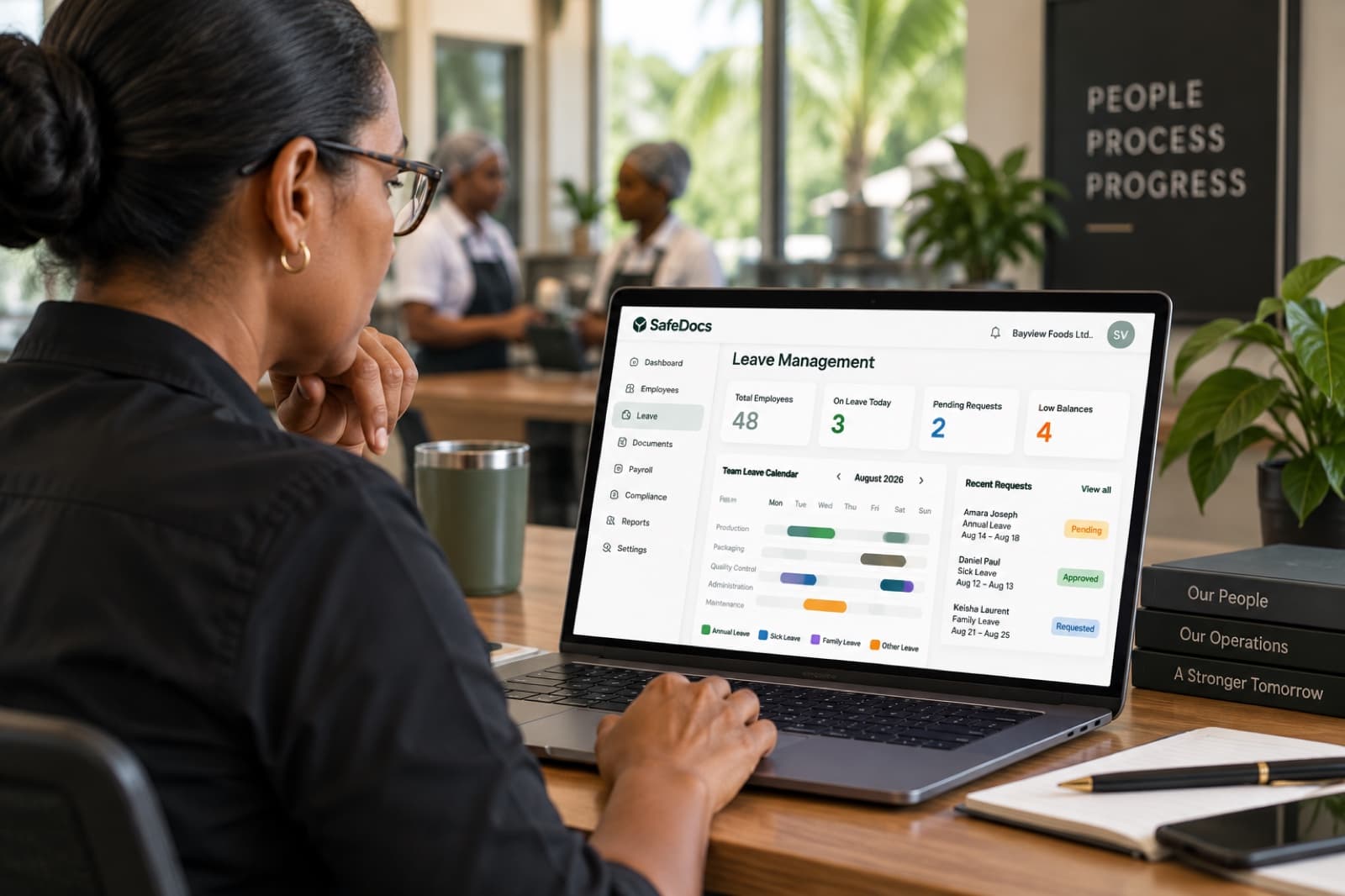 The SafeDocs Leave Management screen showing on-leave counts, pending requests and the team leave calendar, open on a laptop in a bakery