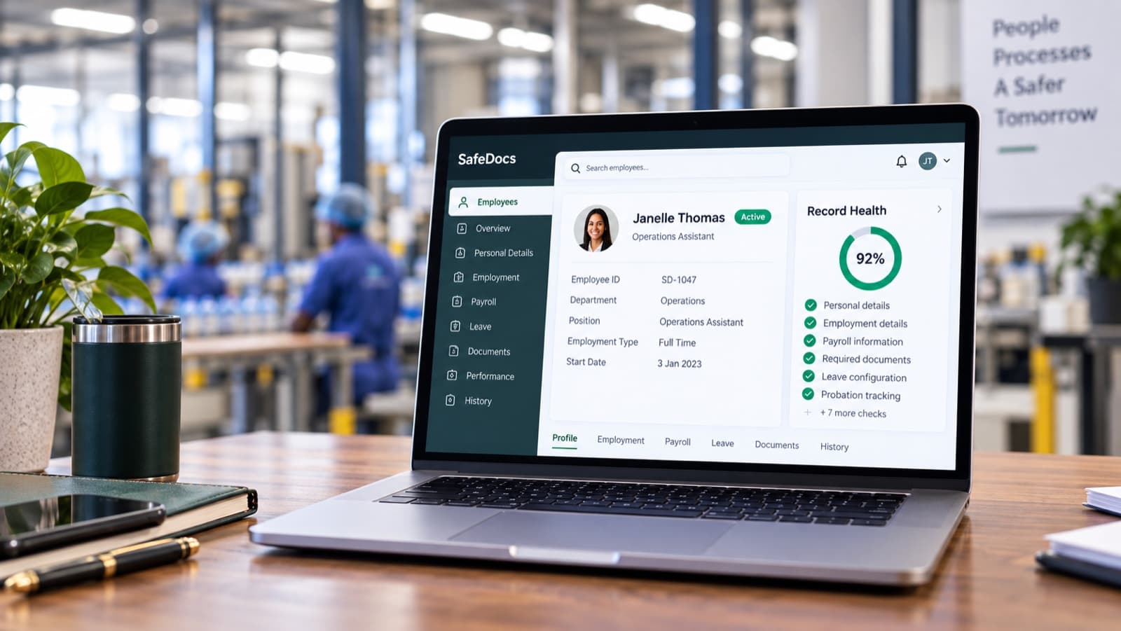The SafeDocs Workforce Records screen showing an employee profile and record health score, open on a laptop on a factory floor